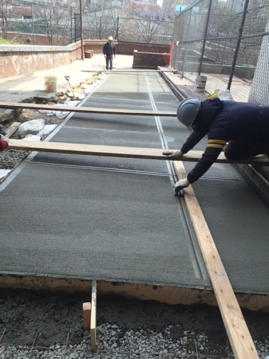 Concrete crew placing and leveling a new exterior slab