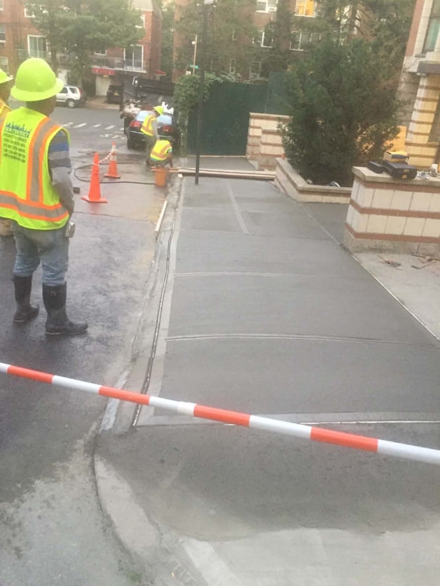 New concrete walkway poured beside a residential property