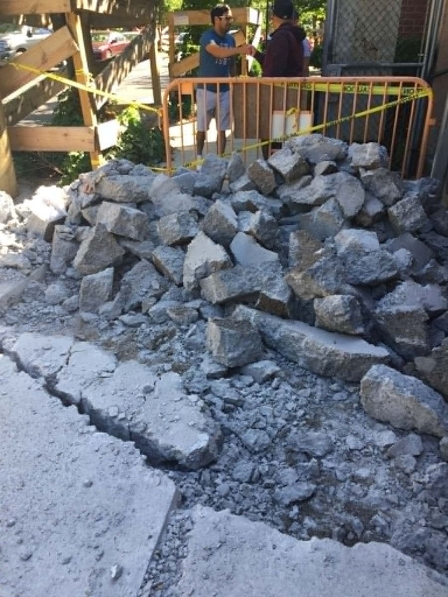 Deteriorated concrete cleared as debris beside a work area