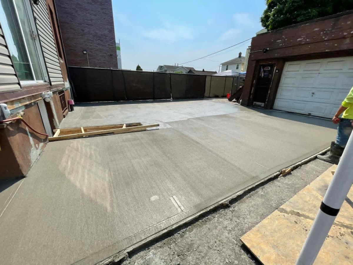 Freshly finished concrete slab beside a residential property