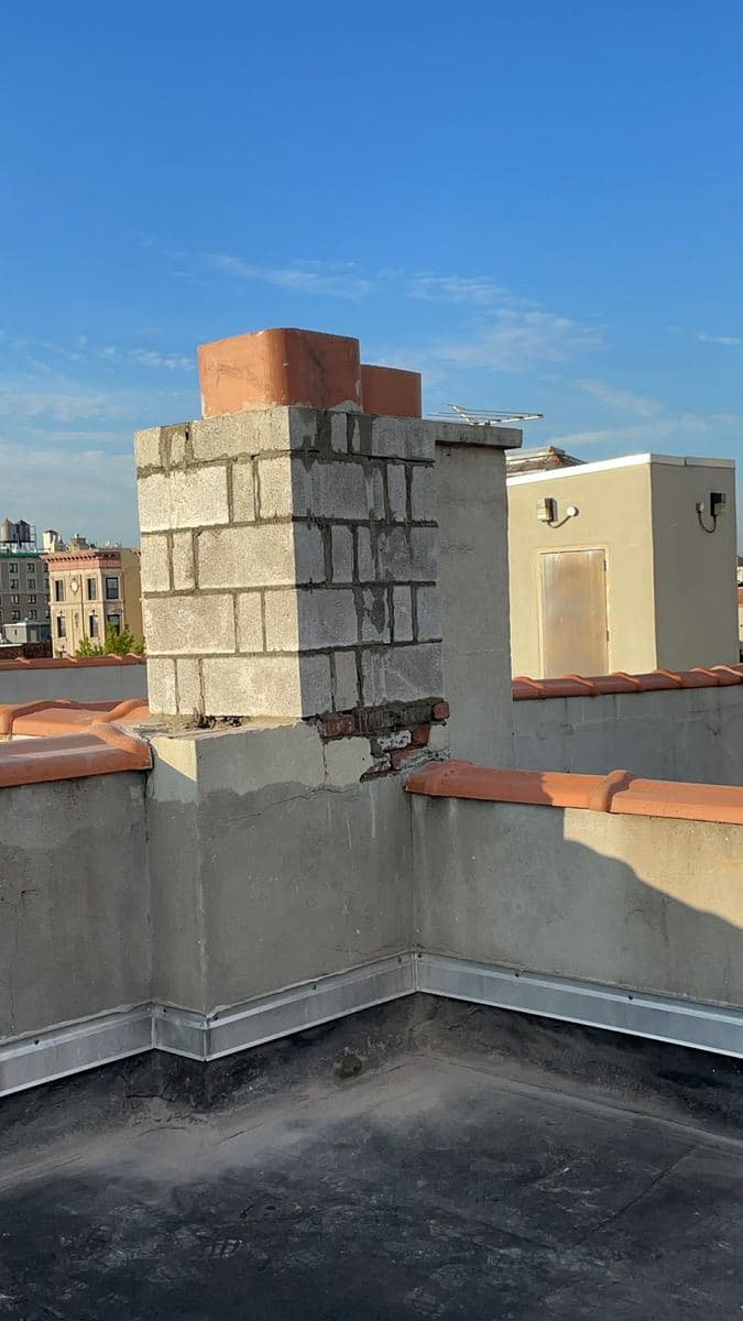 Chimney brickwork being rebuilt against the sky