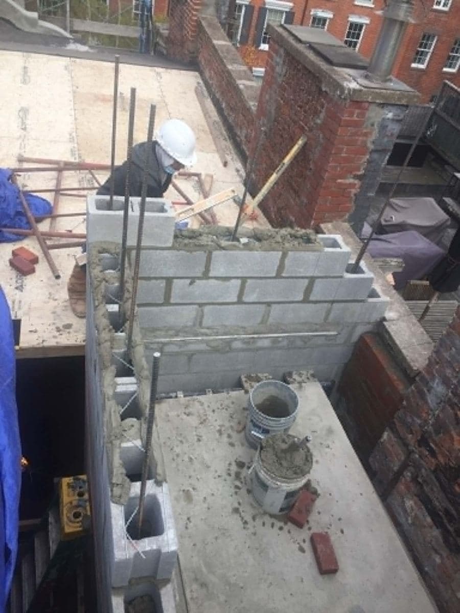 Concrete block wall under construction on a rooftop