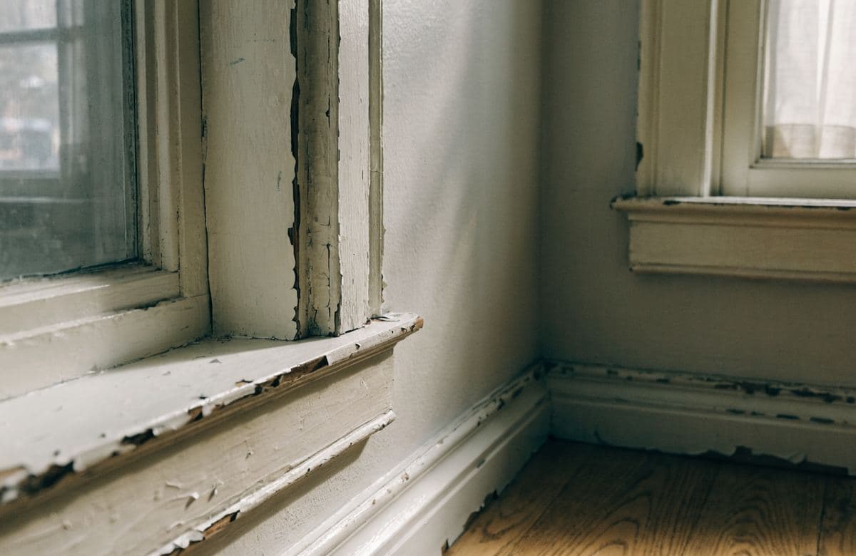 Illustrative interior trim and baseboards with worn, chipped paint