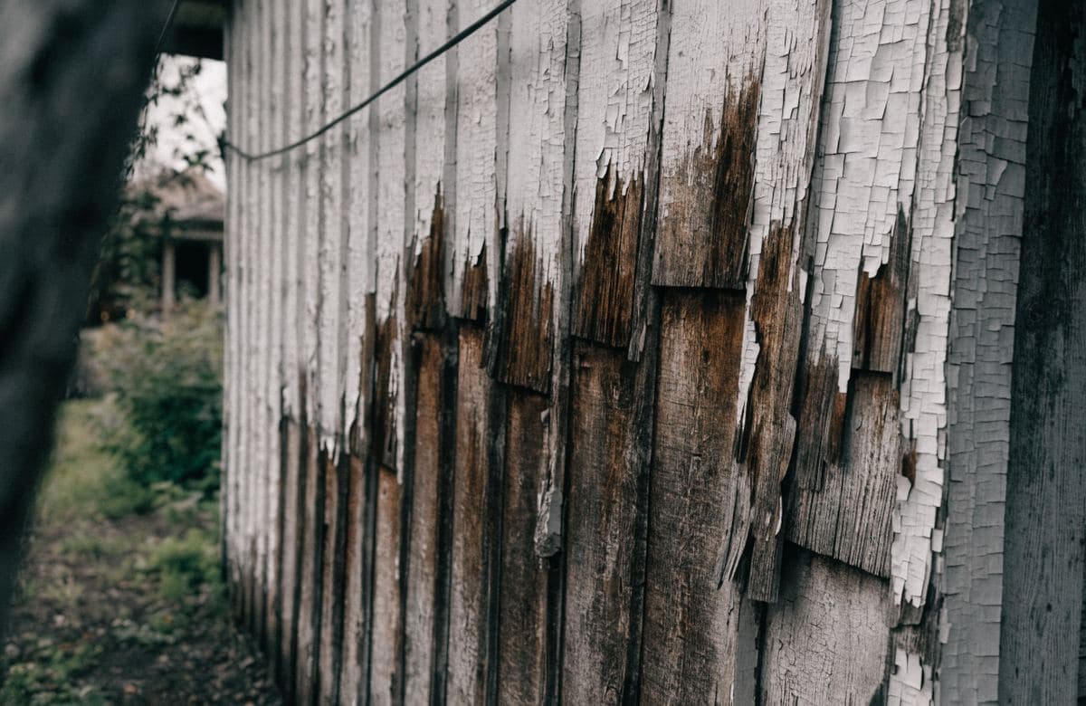 Illustrative weather-exposed exterior wall with faded peeling paint