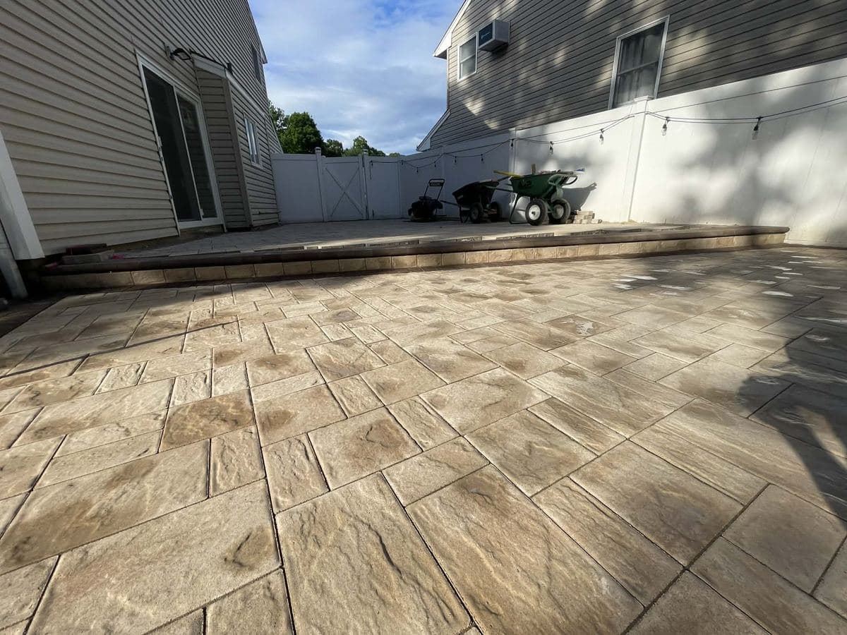 New large-format paver patio installed behind a home