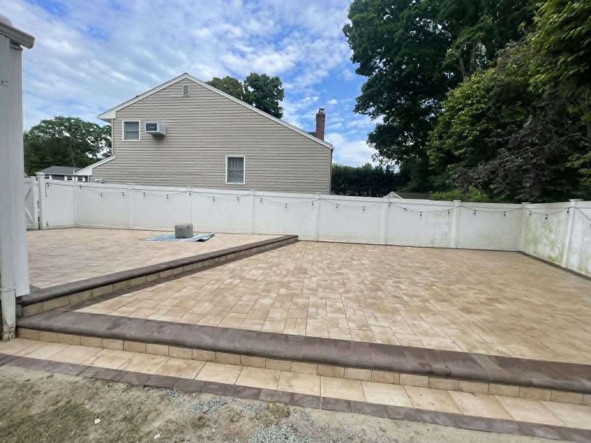 Finished paver patio installed across a residential backyard