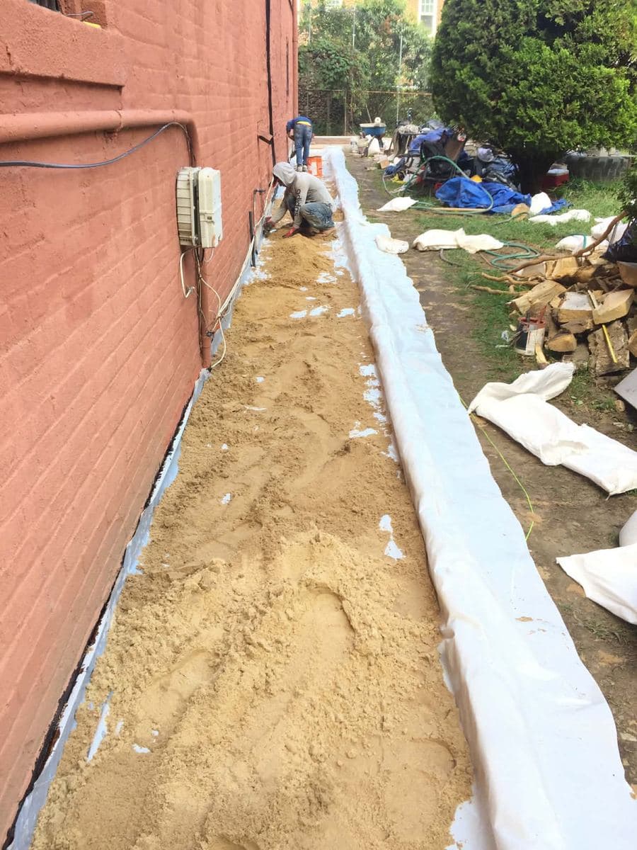Graded base material prepared along a property wall before paving