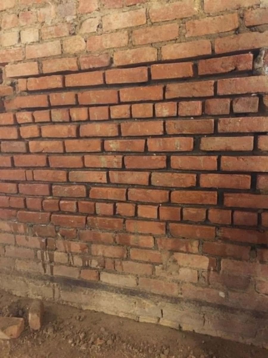 Older brick wall with weathered mortar joints before repair work