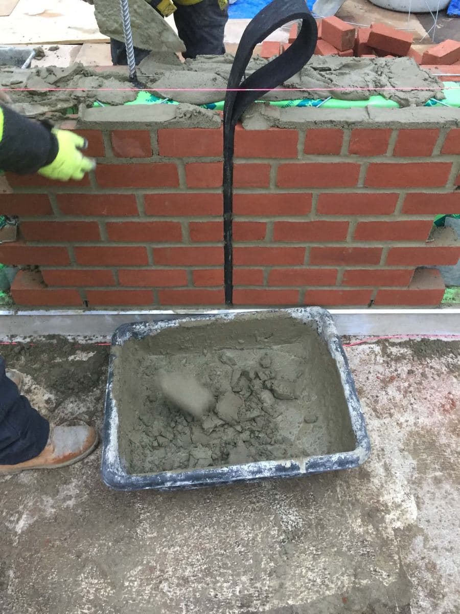Fresh mortar and new brick courses during wall work