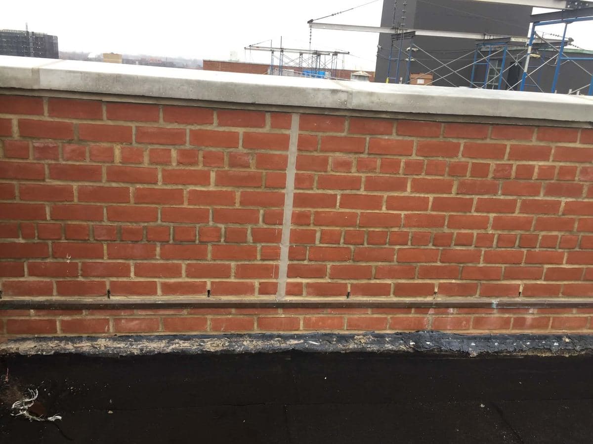 Brick parapet wall with a visible line from a previous mortar repair