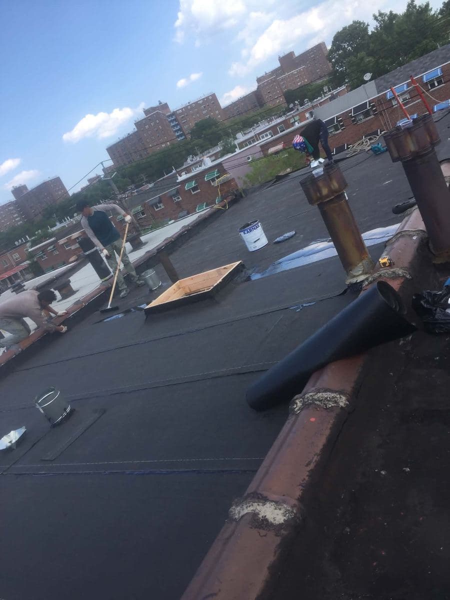 Flat roof with roofing materials staged for installation