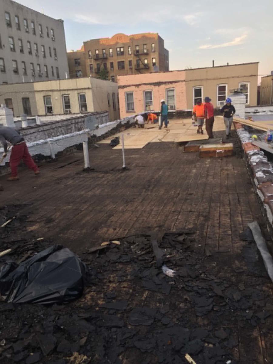 Roofing team preparing a flat roof surface