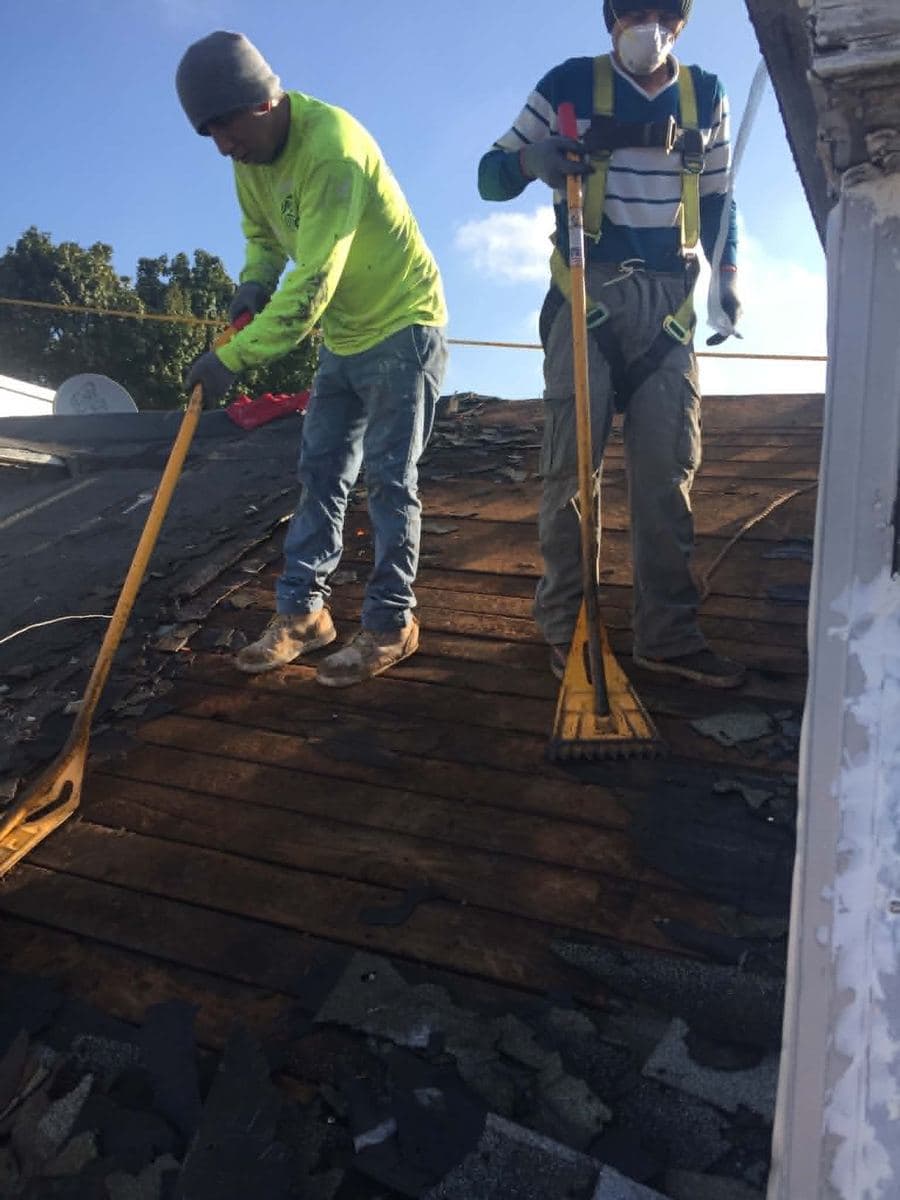 Roofing crew repairing a pitched shingle roof