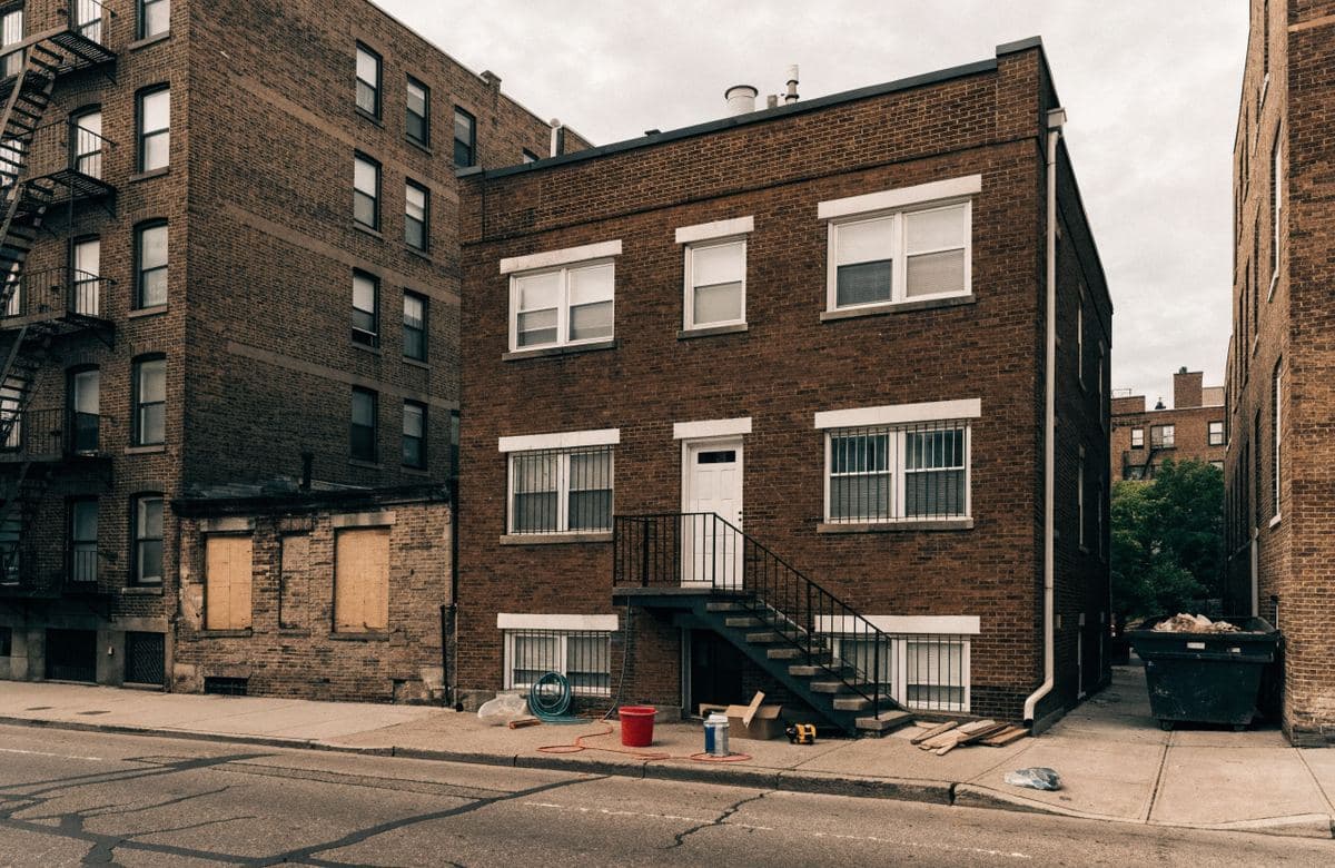 Illustrative small brick rental building with a flat roof