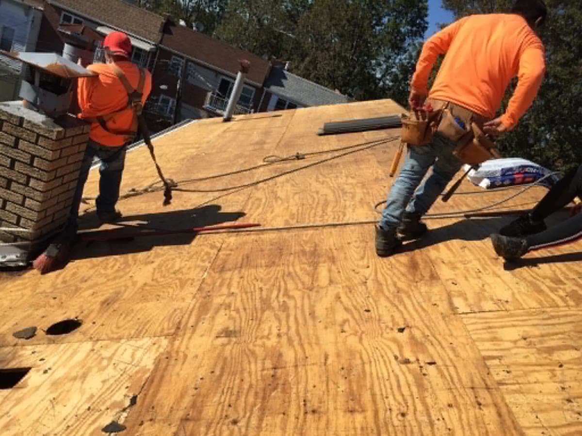 Roofing crew working across a prepared wood roof deck