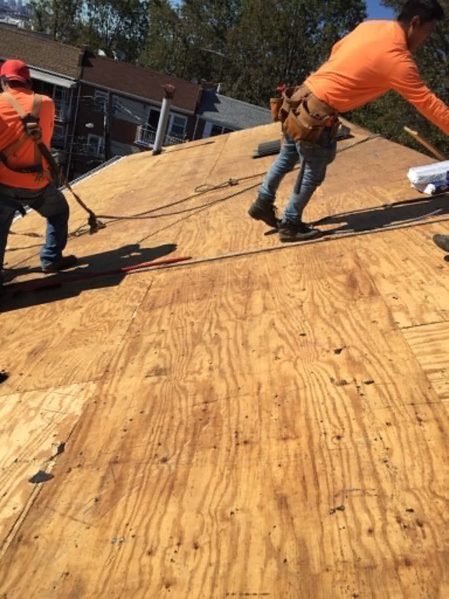Roofing crew working on a newly installed residential roof deck